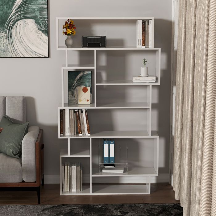 A white bookcase stands in front of a grey wall in a Scandinavian living room.