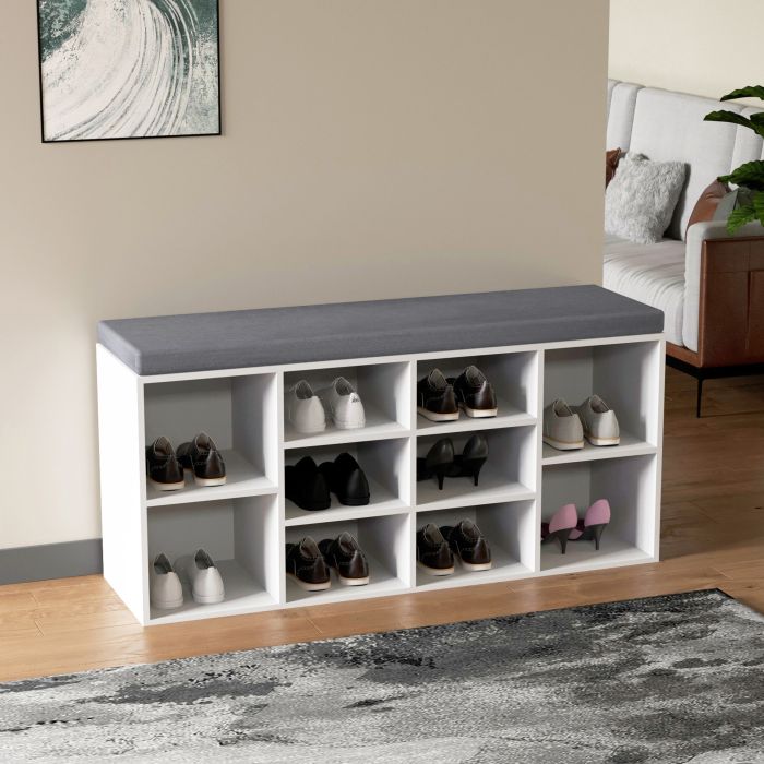 White shoe rack with grey cushion to sit on in a modern and bright entrance area